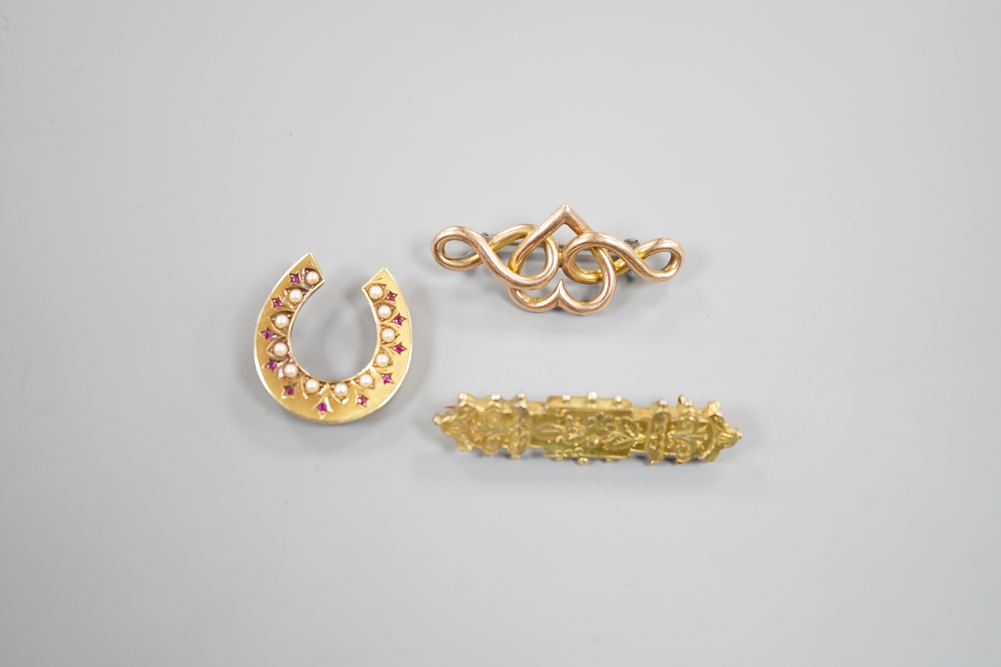 A late Victorian 15ct gold, seed pearl and gem set horseshoe brooch(a.f.), 24mm, 3.6 grams and tow later brooches, one 9ct, gross 8 grams.